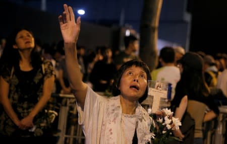 A woman sings religious songs outside the Legislative Council building during a protest against an extradition bill in Hong Kong