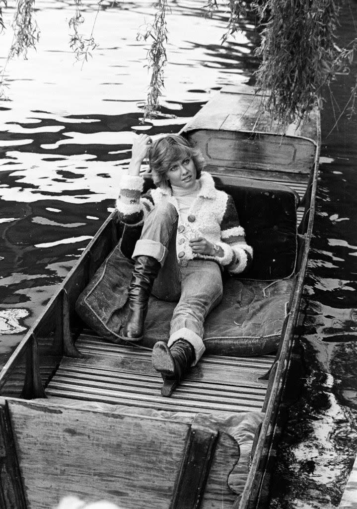 <p>Olivia Newton-John relaxes on a canal boat, while filming her first music video for her single "Follow Me" in 1975. </p>