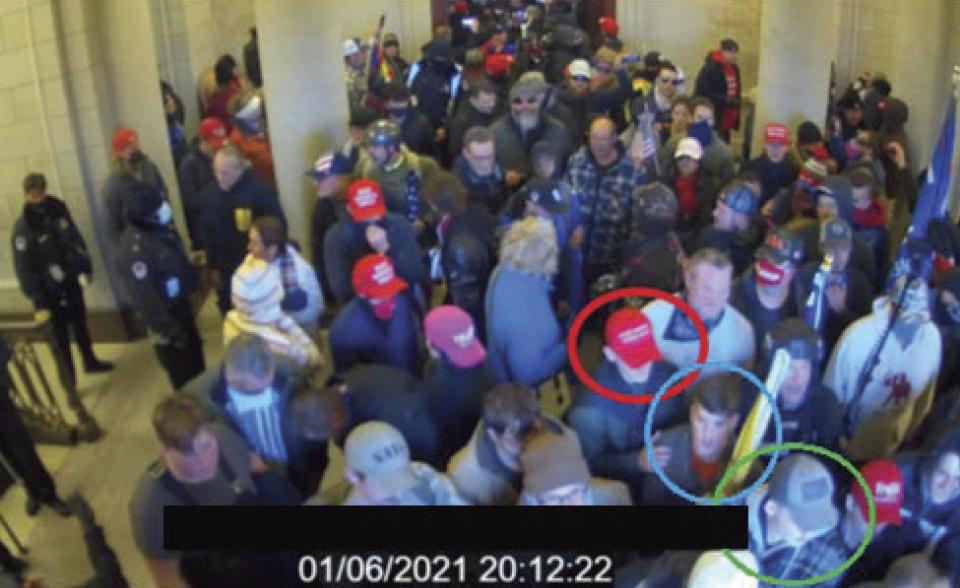 FILE- In this image from U.S. Capitol Police video, released and annotated by the Justice Department in the Statement of Facts supporting an arrest warrant, Joshua Abate, circled in green, Micah Coomer, circled in red, and Dodge Dale Hellonen, circled in blue, appear inside the U.S. Capitol on Jan. 6, 2021, in Washington. Hellonen, one of three active-duty Marines who stormed the U.S. Capitol together, has been sentenced to probation instead of prison time. U.S. District Judge Ana Reyes also on Monday, Sept. 11, 2023, ordered Hellonen to perform 279 hours of community service. (Justice Department via AP, File)