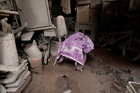 A blanket lies on a chair inside a house affected by the eruption of the Fuego volcano at San Miguel Los Lotes in Escuintla, Guatemala, June 10, 2018. REUTERS/Carlos Jasso