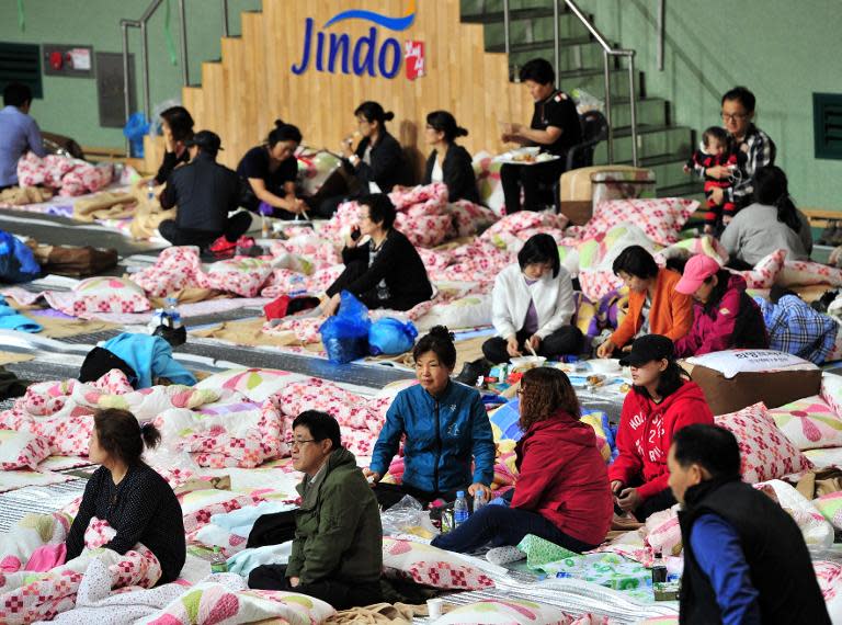 South Korean relatives of passengers on board a capsized ferry gather for news at a gym in Jindo on April 17, 2014