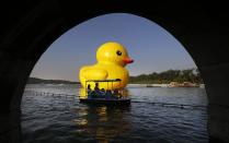 Tourists ride a boat past the inflated Rubber Duck by Dutch conceptual artist Florentijn Hofman on the Kumming Lake at the Summer Palace in Beijing September 26, 2013. REUTERS/Jason Lee