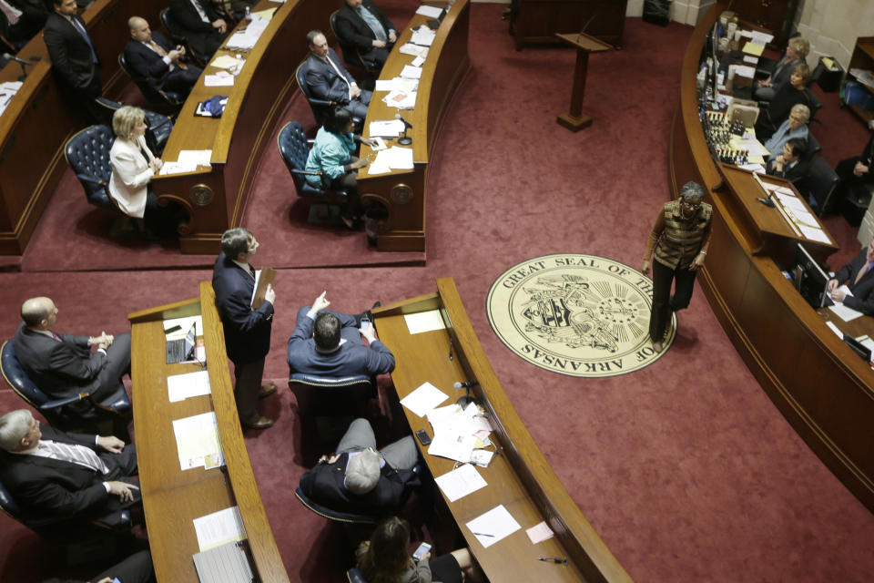 Sen. Stephanie Flowers, D-Pine Bluff, right, walks from the lectern on the floor of the Senate chamber at the Arkansas state Capitol in Little Rock, Ark., after speaking in support of the state's compromise Medicaid expansion plan Thursday, Feb. 20, 2014. The Senate voted to continue the plan. (AP Photo/Danny Johnston)