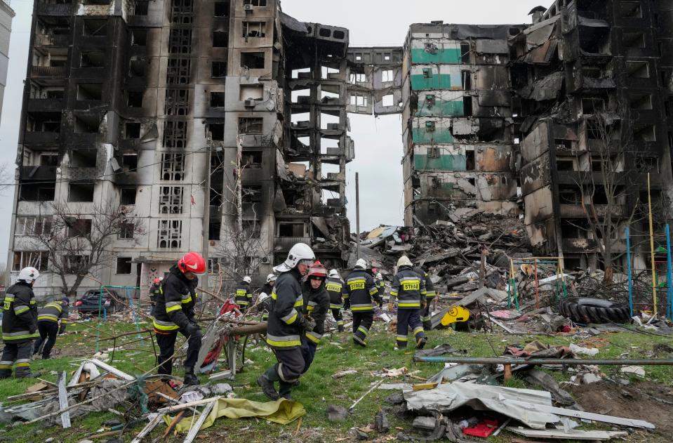 Emergency workers carry debris from a multi-storey building destroyed in a Russian air raid at the beginning of the Russia-Ukraine war in Borodyanka, close to Kyiv, Ukraine, Saturday, April 9, 2022. AP Photo/Efrem Lukatsky