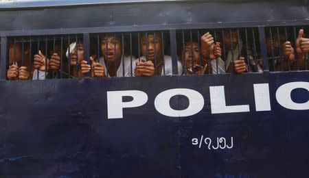 Student protesters look out from a prison vehicle as they are transported to a court in Letpadan March 11, 2015. REUTERS/Soe Zeya Tun