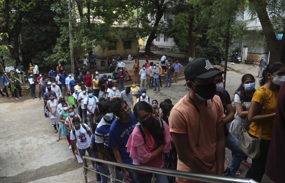 FILE - In this June 11, 2021, file photo, students wait to receive the Covishield, Serum Institute of India's version of the AstraZeneca vaccine, during a special vaccination drive for students traveling overseas, in Hyderabad, India. Starting June 21, 2021, every Indian adult can get a COVID-19 vaccine dose for free that was purchased by the federal government. The policy reversal announced last week ends a complex system of buying vaccines that worsened inequities in accessing vaccines. India is a key global supplier of vaccines and its missteps have left millions of people waiting unprotected. The policy change is likely to address inequality but questions remain and shortages will continue. (AP Photo/Mahesh Kumar A, File)