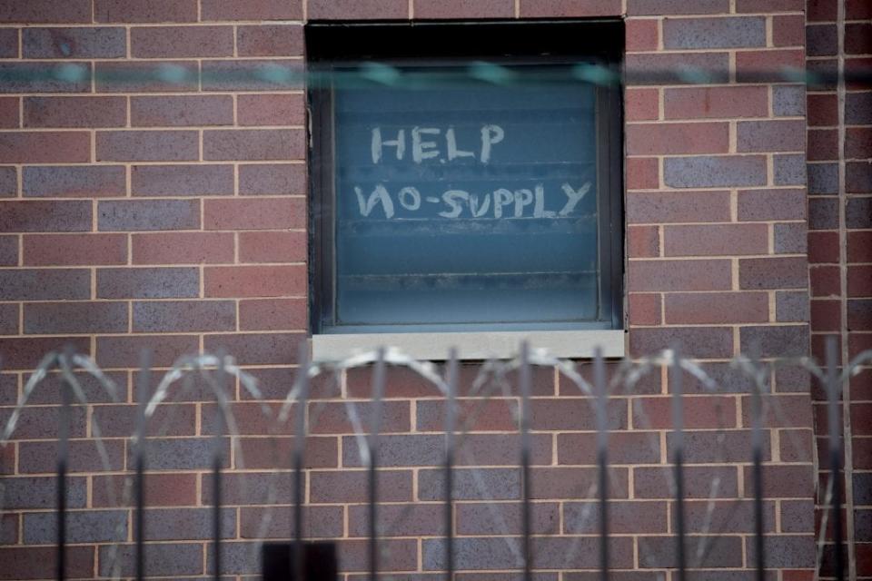 A sign pleading for help hangs in a window at the Cook County jail complex on April 09, 2020 in Chicago, Illinois. (Photo by Scott Olson/Getty Images)