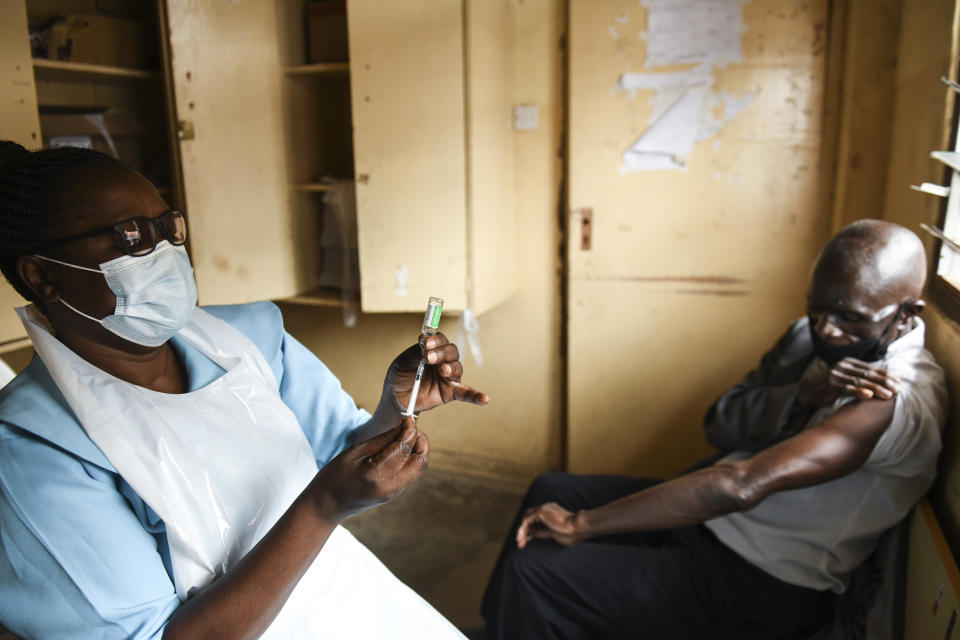 FILE - In this Monday, March 29, 2021 file photo, a man prepares for his AstraZeneca COVID-19 vaccine at Ndirande Health Centre in Blantyre, Malawi. Some Africans are hesitating to get COVID-19 vaccines amid concerns about their safety, alarming public health officials as some countries start to destroy thousands of doses that expired before use. (AP Photo/Thoko Chikondi, File)