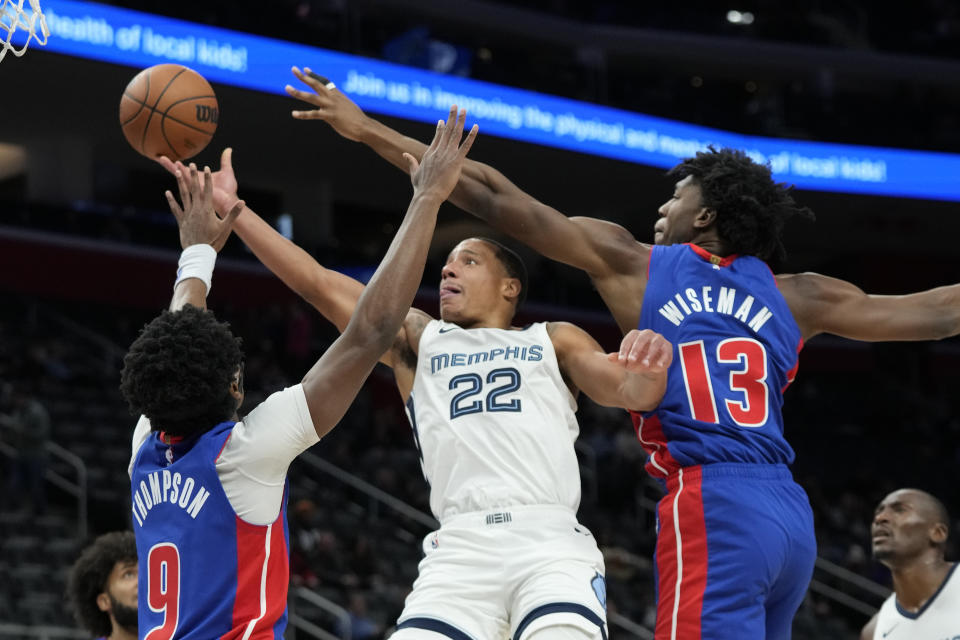 Memphis Grizzlies guard Desmond Bane (22) is defended by Detroit Pistons forward Ausar Thompson (9) and center James Wiseman (13) during the first half of an NBA basketball game, Wednesday, Dec. 6, 2023, in Detroit. (AP Photo/Carlos Osorio)