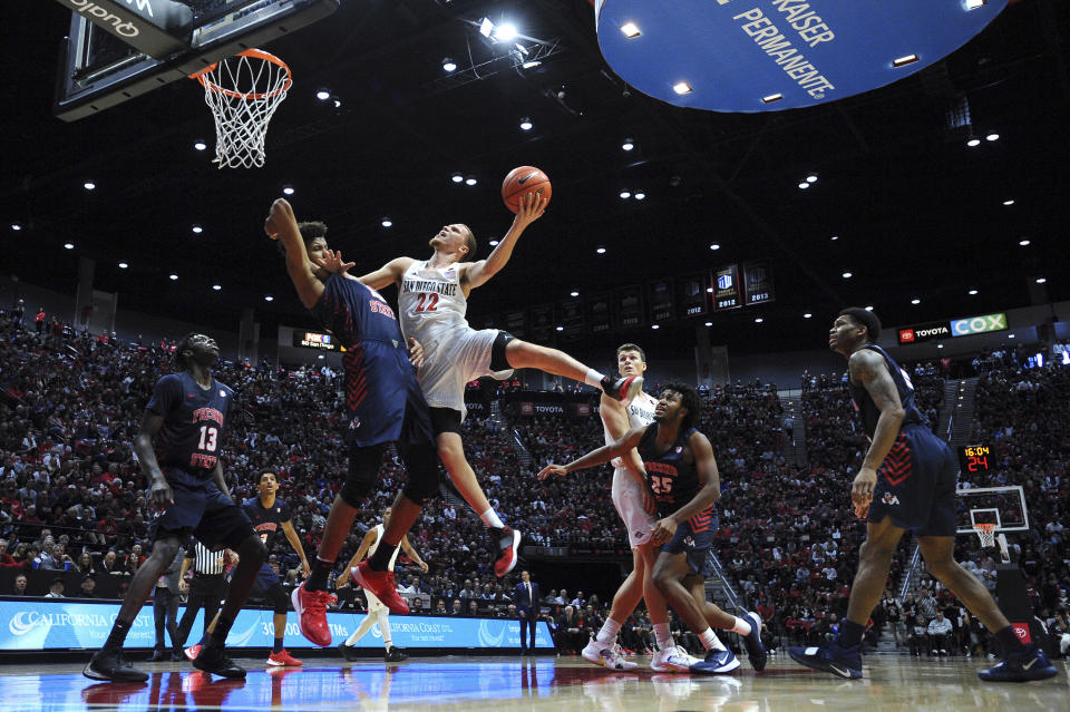 San Diego State guard Malachi Flynn (22) goes to the basket while defended by Fresno State forward Orlando Robinson (10) during the second half of an NCAA college basketball game Wednesday, Jan. 1, 2020, in San Diego. San Diego won 61-52. (AP Photo/Orlando Ramirez)