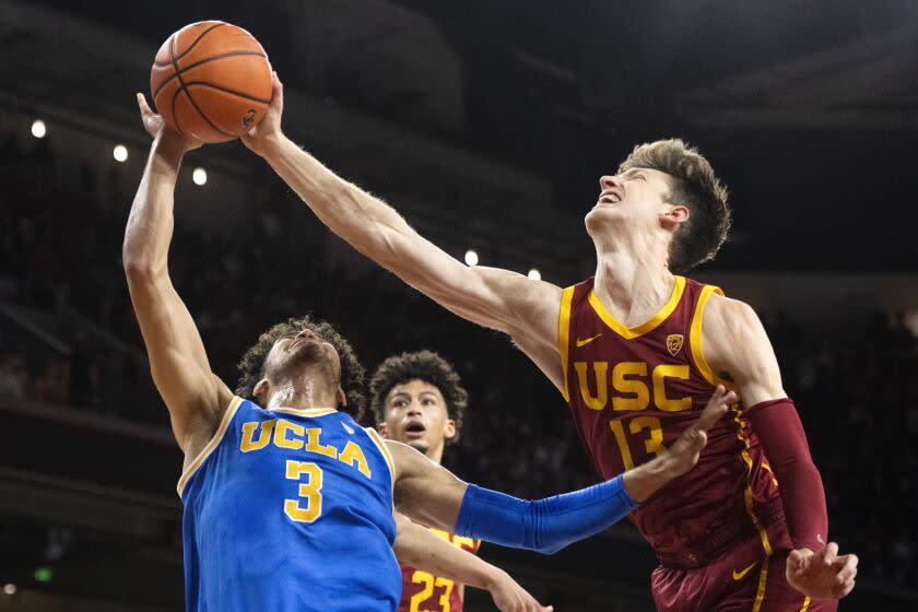 Southern California guard Drew Peterson (13) blocks a shot by UCLA guard Johnny Juzang.