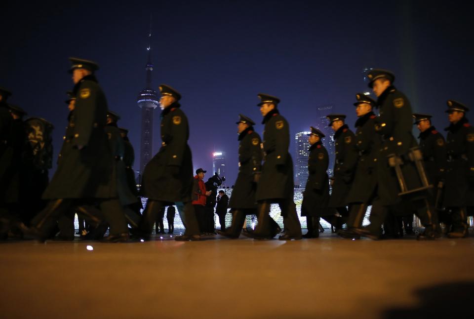 Paramilitary police officers walk on the location where people were killed in a stampede incident during a New Year's celebration on the Bund in Shanghai