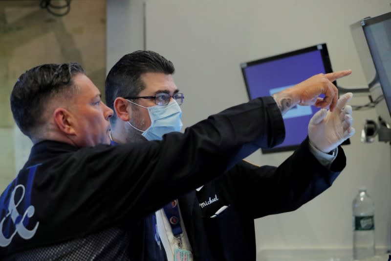 FILE PHOTO: Traders work on the floor of the New York Stock Exchange (NYSE) as the building prepares to close indefinitely due to the coronavirus disease (COVID-19) outbreak in New York