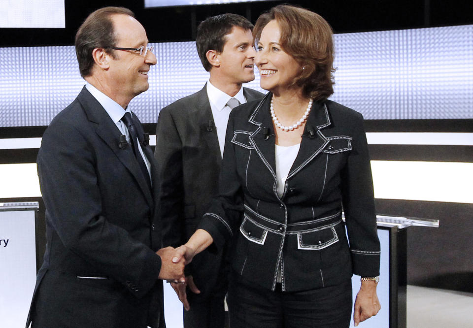 FILE - In this Sept. 15, 2011 file photo, candidates for the 2011 French Socialist party primary elections Francois Hollande, left, shakes hands with Segolene Royal, right, while Manuel Valls, center back, looks on before a televised debate in Paris. Royal, French President Francois Hollande's former partner, has been named Wednesday April, 2, 2014 as Minister of Environment and Energy. Valls is now Prime Minister. (AP Photo/Patrick Kovarik, Pool-File)