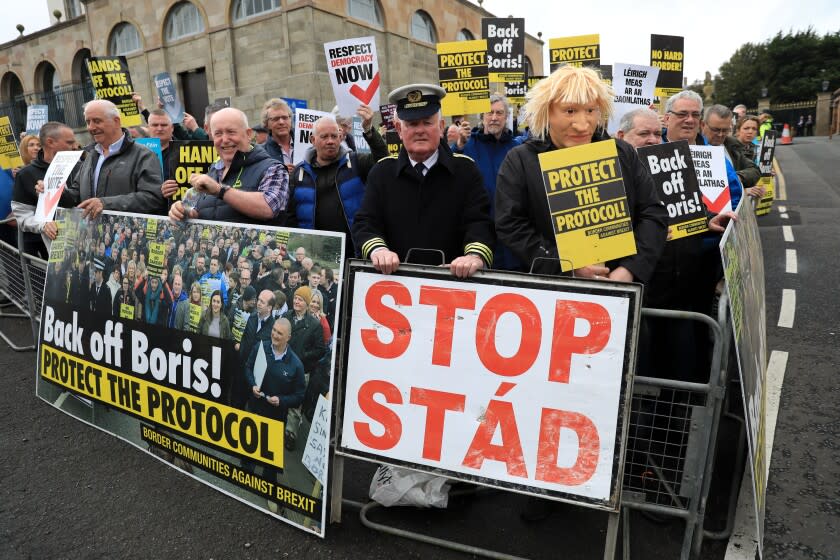 FILE - Demonstrators protest outside Hillsborough Castle, ahead of a visit by British Prime Minister Boris Johnson, in Hillsborough, Northern Ireland, Monday, May, 16, 2022. Britain's government is expected to introduce legislation that would unilaterally change post-Brexit trade rules for Northern Ireland amid opposition from lawmakers who believe the move violates international law. The legislation, expected Monday, June 13, 2022, would let the government bypass the so-called Northern Ireland Protocol, which requires the inspection of some goods shipped there from other parts of the United Kingdom. (AP Photo/Peter Morrison, File)