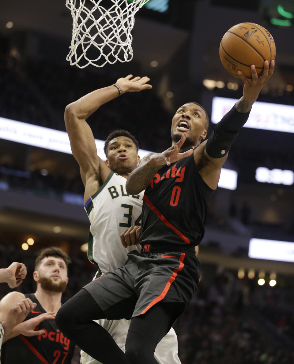 FILE - Portland Trail Blazers' Damian Lillard (0) drives against Milwaukee Bucks' Giannis Antetokounmpo (34) during the second half of an NBA basketball game Wednesday, Nov. 21, 2018, in Milwaukee. Damian Lillard is being traded by Portland to play alongside Antetokounmpo in Milwaukee, a person with knowledge of the agreement said Wednesday, Sept. 27, 2023, a move that ends a three-month saga surrounding his wish to be moved elsewhere with hopes of winning an NBA title and ending his 11-year run with the Trail Blazers. (AP Photo/Jeffrey Phelps, File)