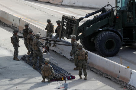 U.S. Marines work to move building materials as they harden the border with Mexico in preparation for the arrival of a caravan of migrants at the San Ysidro border crossing in San Diego, California, U.S., November 13, 2018. REUTERS/Mike Blake