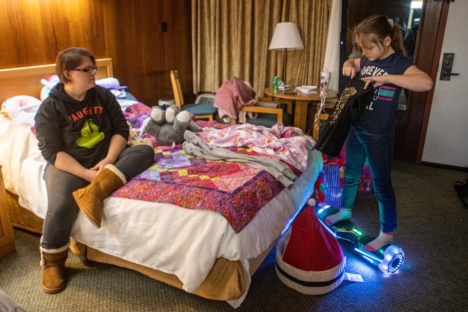 Lacy Duke, left, watches as her daughter, Pearlena Hoffhines, 9, picks out her clothes in their room at the Pennyrile Forest State Resort Park the night before classes resume at Dawson Springs, Kentucky schools. As school resumes, Duke is worried she may face new challenges since being displaced by the Dec. 10 tornado. Jan. 17, 2022