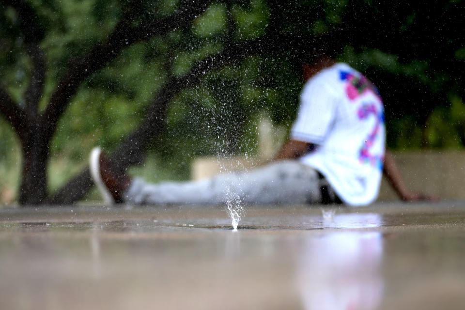 A man who said he was homeless tries to keep cool on a children's splash pad, Tuesday, June 25, 2024 in Phoenix. Sizzling sidewalks and unshaded playgrounds increasingly are posing risks for surface burns as air temperatures reach new high during the searing summers in Southwest cities like Phoenix and Las Vegas. Very young children and older adults are especially at risk for contact burns. So are homeless people. (AP Photo/Matt York)