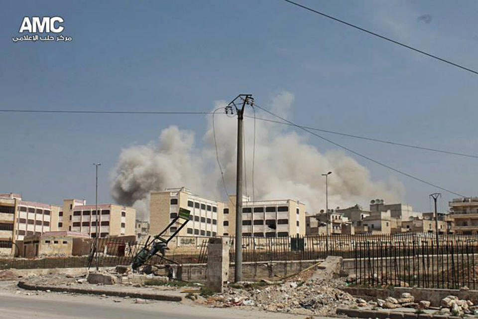 In this photo provided by the anti-government activist group Aleppo Media Center (AMC), which has been authenticated based on its contents and other AP reporting, smoke rises after a government warplane dropped barrel bombs at al-Sakhour neighborhood in Aleppo, Syria, Saturday, April 5, 2014. The leader of al-Qaida, Ayman al-Zawahri , called on Syrian militant groups to determine who killed his representative in the country, a man many fighters believe died at the hands of a rival militia. (AP Photo/Aleppo Media Center, AMC)
