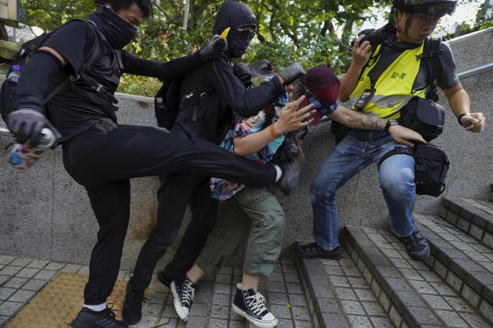 Protesters attack a man who was trying to stop them for vandalizing near the Tsim She Tsui police station during a rally in Hong Kong, Sunday, Oct. 20, 2019. Hong Kong protesters again flooded streets on Sunday, ignoring a police ban on the rally and demanding the government meet their demands for accountability and political rights. (AP Photo/Vincent Yu)
