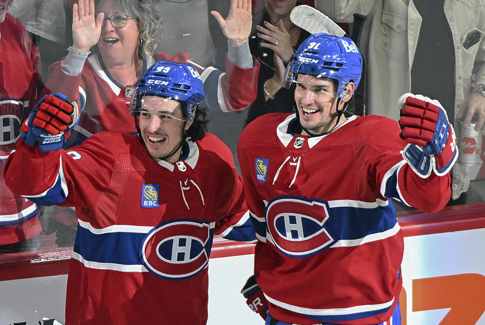 Montreal Canadiens' Sean Monahan (91) celebrates with teammate Rafael Harvey-Pinard (49) after scoring against the Chicago Blackhawks during the second period of an NHL hockey game in Montreal, Saturday, Oct. 14, 2023. (Graham Hughes/The Canadian Press via AP)