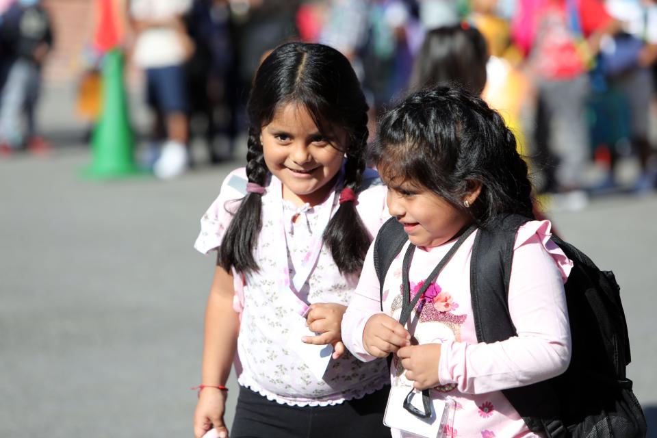 Students chat as they enter the building for the first day of school at Woodside Elementary, a K-1 school in Peekskill, Sept. 1, 2022.