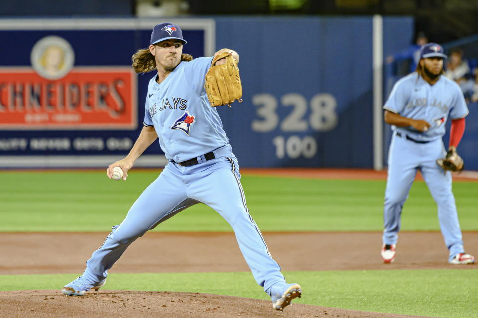 Toronto Blue Jays starting pitcher Kevin Gausman, left, throws during the first inning of a baseball game against the Houston Astros in Toronto, Sunday, May 1, 2022. (Christopher Katsarov/The Canadian Press via AP)