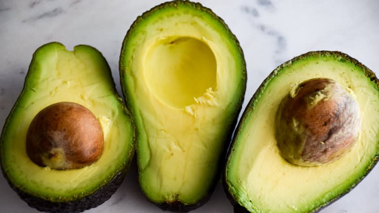 Avocados cut open with pits