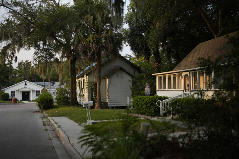 Eatonville's oldest building, the Historic Thomas House, sits between its second oldest, the Moseley House Museum, right, and St. Lawrence African Methodist Episcopal Church, left, a congregation that predates the town's 1887 incorporation as a self-governing Black municipality, Wednesday, Aug. 23, 2023, in Eatonville, Fla. The Thomas House building first served as a house of worship, shared between St. Lawrence AME Church and Macedonia Missionary Baptist Church, then the town's first library and a "juke joint" for entertainment, before being purchased by the Thomas family as a residence. (AP Photo/Rebecca Blackwell)