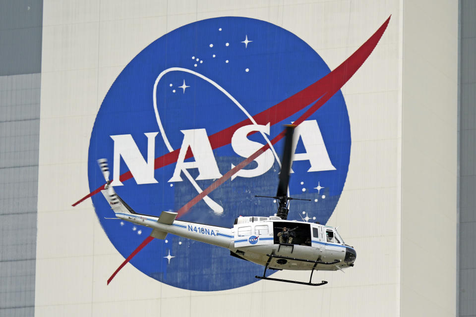 A NASA helicopter escorts the crew to Launch Pad 39-A, Wednesday, May 27, 2020, at Kennedy Space Center in Cape Canaveral, Fla. Two astronauts will fly on the SpaceX Demo-2 mission to the International Space Station scheduled for launch Wednesday. (AP Photo/David J. Phillip)