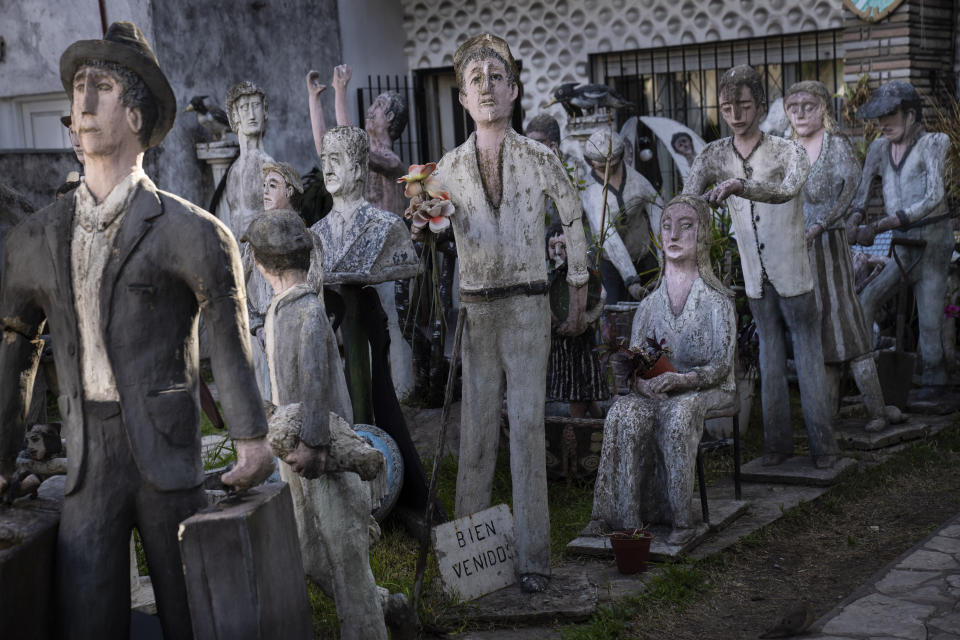 Figuras a escala humana que representan a inmigrantes se exhiben en el jardín delantero de la casa familiar del italiano Antonio Ierace, en Ciudadela, Argentina, el lunes 17 de octubre de 2022. (AP Foto/Rodrigo Abd)