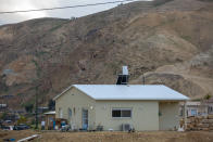 In this Monday, Feb. 10, 2020 photo, a boy plays next to his home in the Jewish settlement of Mevo'ot Yericho, in the Jordan Valley near the Palestinians city of Jericho. Israel's Prime Minister Benjamin Netanyahu is eager to court the votes of the country's influential West Bank settlers in critical elections next month. President's Donald Trump's Mideast plan seemed to be the key to ramping up their support. The plan envisions Israel's eventual annexation of its scores of West Bank settlements — a long time settler dream. But in the weeks since it was unveiled, Netanyahu has stumbled over his promises to quickly carry out the annexation, sparking verbal attacks from settler leaders. (AP Photo/Ariel Schalit)