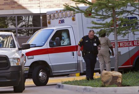 An ambulance driver wearing a protective suit escorts Amber Joy Vincent (not shown), the second health worker to be infected with the Ebola virus at Texas Health Presbyterian Hospital to the airport in Dallas, Texas October 15, 2014. REUTERS/Jaime R. Carrero