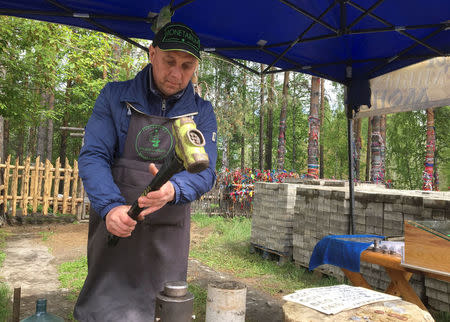 Sergei Brik, who strikes souvenir coins for tourists, works in Yekaterinburg, Russia June 16, 2018. REUTERS/Mark Trevelyan