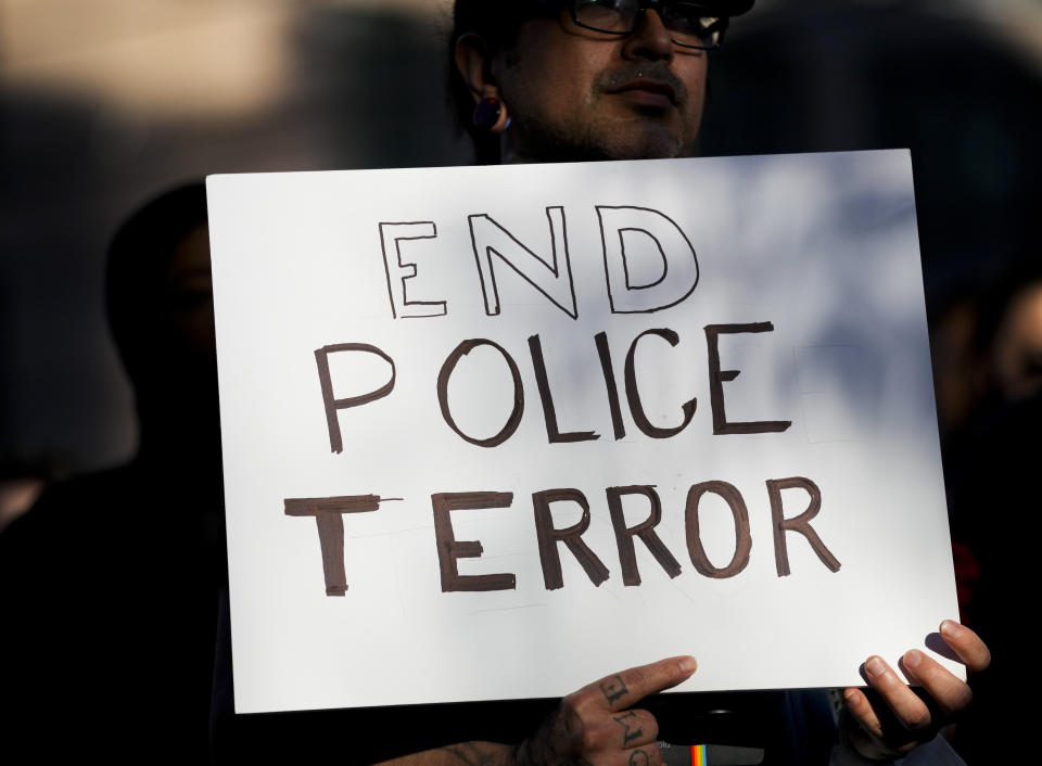 A protester holds a sign reading, "End police terror," as people rally after body camera footage was released of a Seattle police officer joking about the death of Jaahnavi Kandula, a 23-year-old woman hit and killed in January by officer Kevin Dave in a police cruiser, Thursday, Sept. 14, 2023, in Seattle. (AP Photo/Lindsey Wasson)