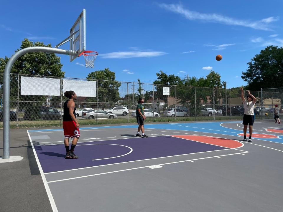 Daniel Vela (from left), Tomas Pinet and Nata Pinet shoot hoops Thursday at the newly renovated basketball courts at Burnham Playfield.