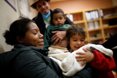 Honduran migrants Maria, 6, and David, 2, meet their newborn brother Alvin for the first time, as they stand with their parents Erly Marcial, 21, and Alvin Reyes, 39, at a hospital in Puebla, Mexico, November 13, 2018. REUTERS/Carlos Garcia Rawlins