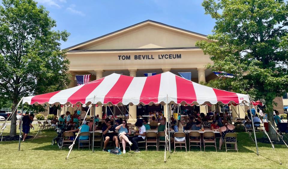 Attendees of the Latino Festival on the campus of Northeast Alabama Community College enjoy Hispanic food and events in the shade of tent on June 10, 2023.