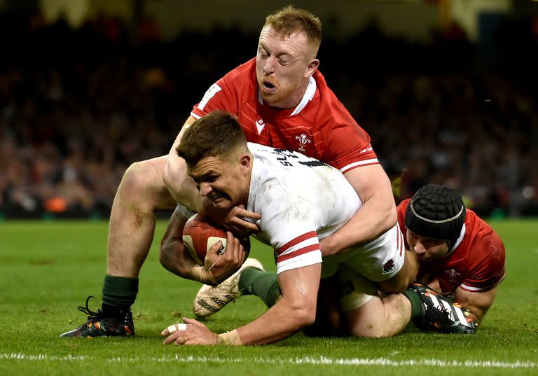 Henry Slade, de Inglaterra, es tackleado por Tommy Reffell, de Gales; el del Dragón y la Rosa fue un enfrentamiento muy físico en Cardiff.