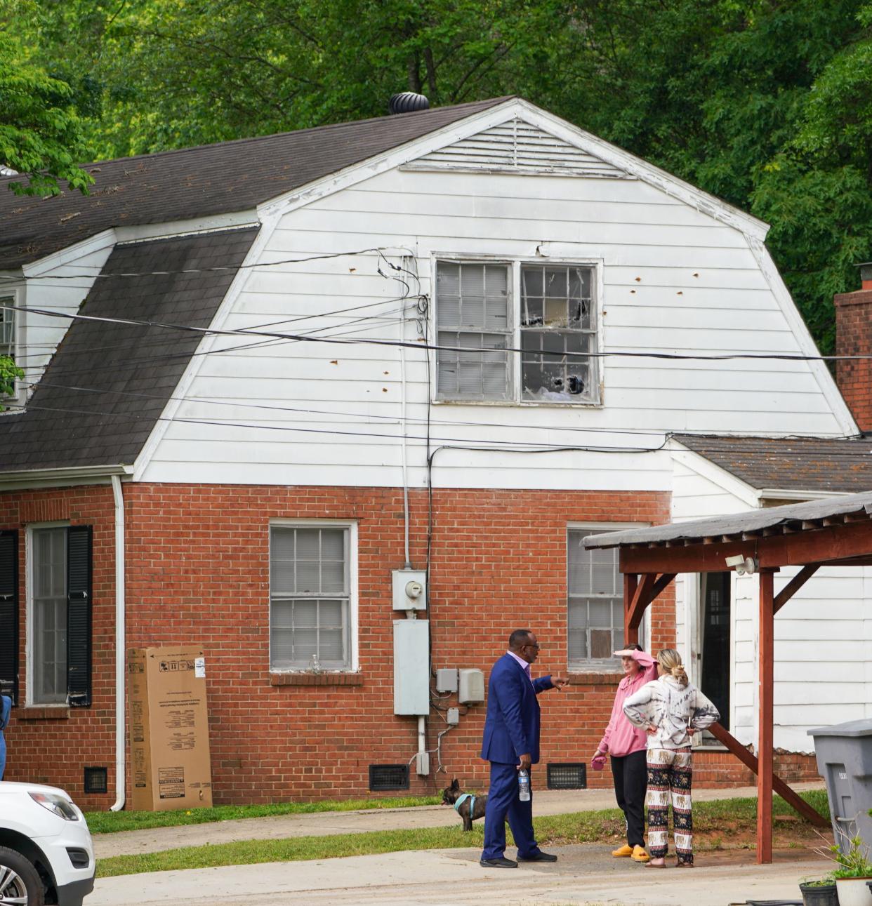 People stand outside a house that was the scene of an incident on April 29, 2024, where four law enforcement officers, including three on a U.S. Marshals Task Force, were killed and four other officers were injured after being shot while attempting to serve a warrant in Charlotte, N.C.