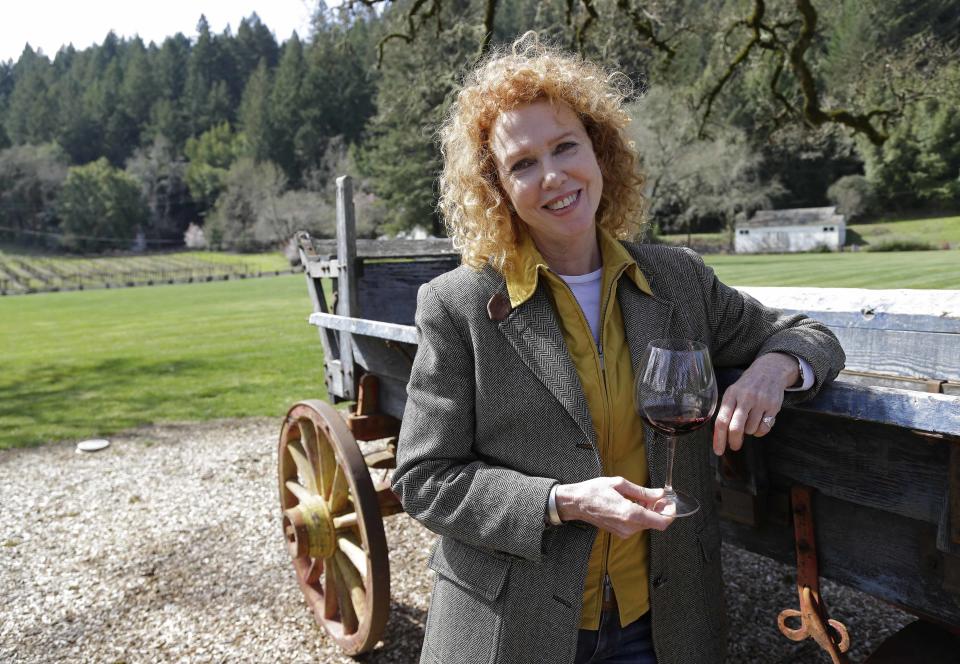 In this photo taken March 15, 2013 Kate MacMurray, daughter of the late actor Fred MacMurray poses by an old wooden wagon used for diversified farming in World War II and then for cattle at the MacMurray Ranch in Healdsburg, Calif. The former cattle ranch which was purchased in 1941 by the actor in the popular TV series "My Three Sons," now produces wine and is owned by the Gallo wine family. (AP Photo/Eric Risberg)