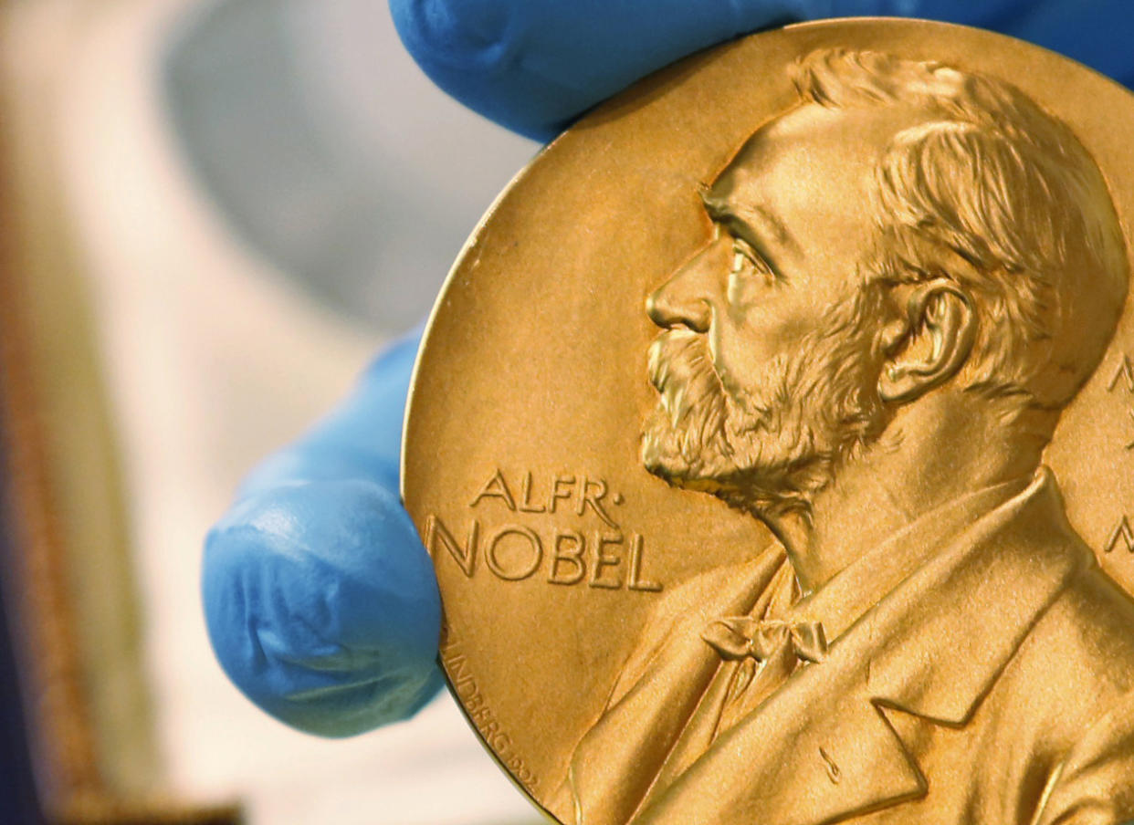 FILE - In this April 17, 2015 file photo, a national library employee shows a gold Nobel Prize medal. The Nobel Peace Prize will be awarded on Friday Oct. 8, 2021. (AP Photo/Fernando Vergara, File)