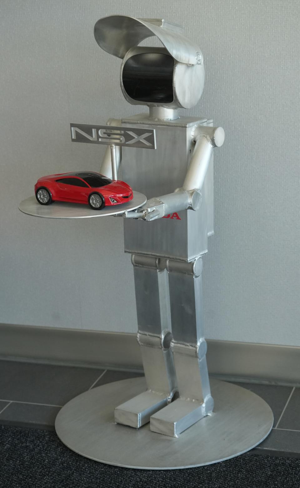 A little metal robot sculpture with an Acura NSX on a tray greets visitors to the Performance Manufacturing Center near Marysville.