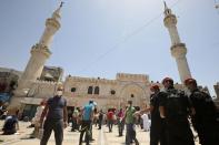 Jordanian policemen stand guard as Muslims attend Friday prayers at al Husseini mosque in Amman