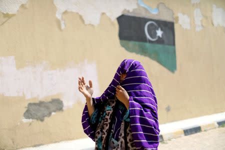 A Libyan displaced woman, who fled her house because of the fighting between the Eastern forces commanded by Khalifa Haftar and the internationally recognised government, reacts at Bader School, which is used as a shelter, in Tripoli, Libya April 14, 2019. REUTERS/Ahmed Jadallah