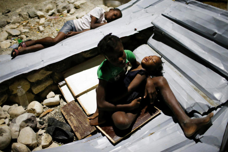 <p>Children sleep over metal sheets in a partially destroyed school used as a shelter after Hurricane Matthew hit Jeremie, Haiti, October 11, 2016. (Carlos Garcia Rawlins/Reuters)</p>