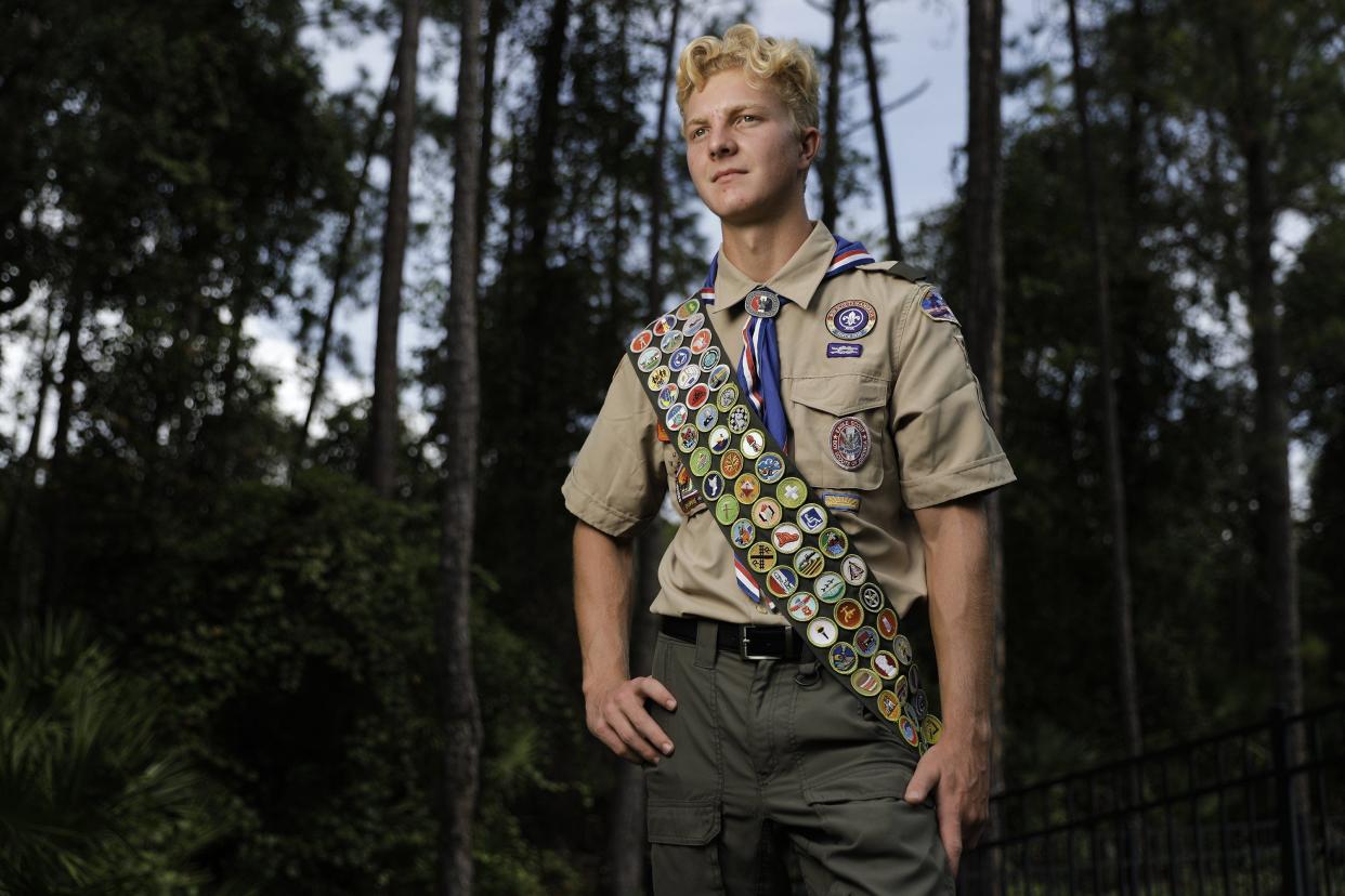 Tre Peterson dons his Boy Scout uniform with a sash that's covered, front and back, with merit badges outside his Nocatee home. Somehow he'll have to find room for the final five he's earned.