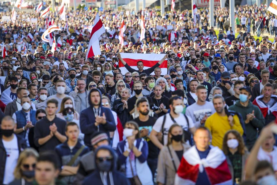 Protesters with old Belarusian national flags march during an opposition rally to protest the official presidential election results in Minsk, Belarus, Sunday, Sept. 20, 2020. Protests calling for the authoritarian president's resignation broke out after an Aug. 9 election that officials say gave him a sixth term in office and that opponents say was rigged. (AP Photo/TUT.by)