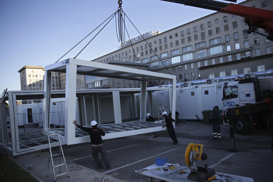 ARCHIVO - En esta imagen de archivo del 18 de enero de 2021 trabajadores colocando módulos para ampliar la capacidad de urgencias del Hospital Santa María en Lisboa. (AP Foto/Armando Franca, Archivo)